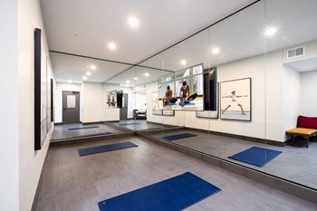 a yoga room with mirrors and blue yoga mats